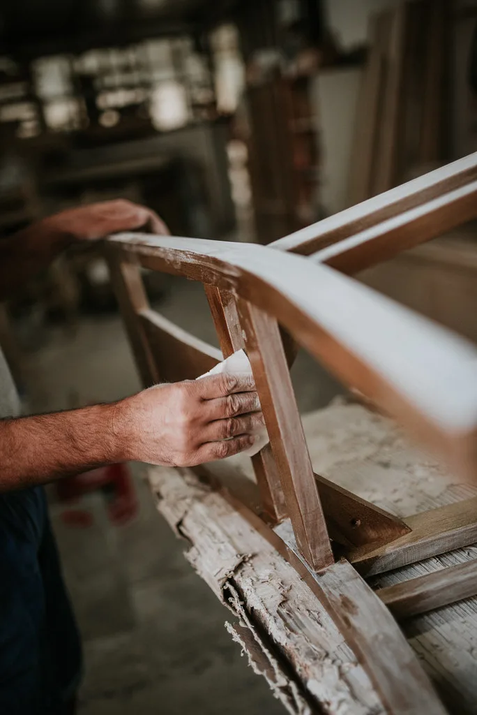 A compact home workshop with a table saw on a mobile stand and organized tools in natural light.