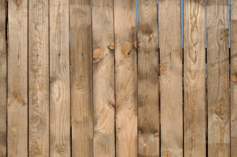 Wood privacy fence panels in a backyard, with different panel types installed side by side