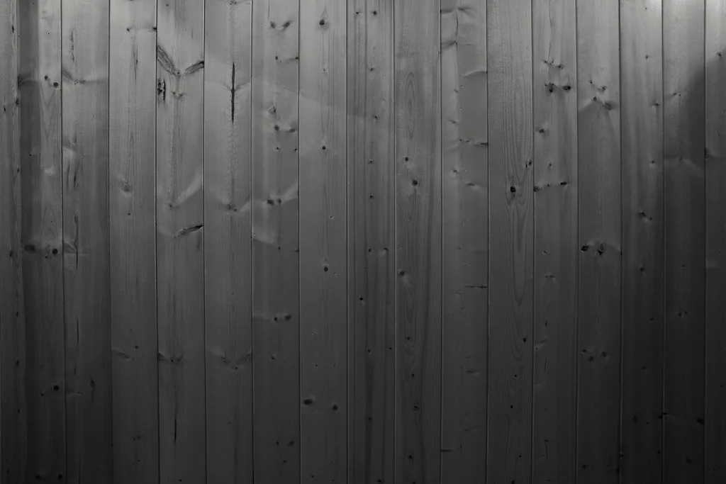 Close-up of a wood privacy fence panel post connection with screws and a level