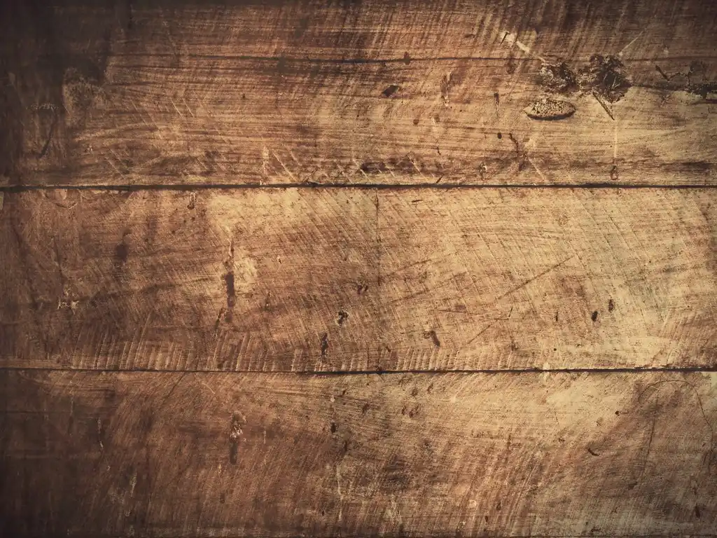 Close-up of wood filler being applied to a chipped MDF edge with a putty knife