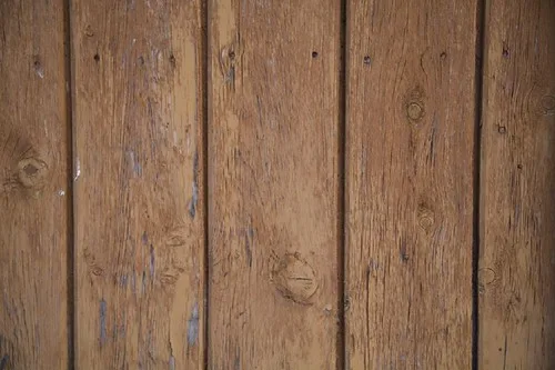 Close-up of herringbone wood flooring samples and a tape measure on a small room floor