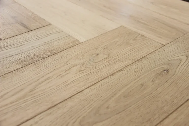 Herringbone floor installation with wood sample boards laid beside partially installed planks