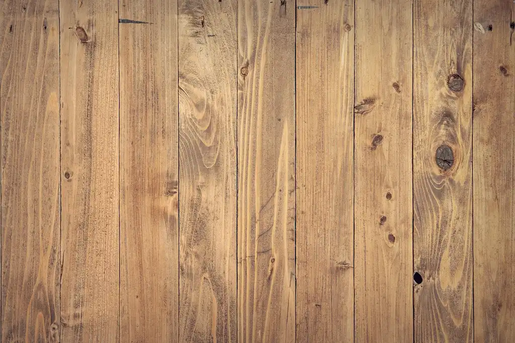 Contractor and homeowner reviewing engineered hardwood planks and tools in a bright living room