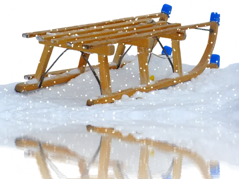 Partially built wooden sleigh on sawhorses with measuring tools and lumber in a workshop