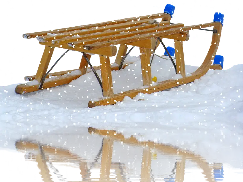 Partially built wooden sleigh on sawhorses with measuring tools and lumber in a workshop