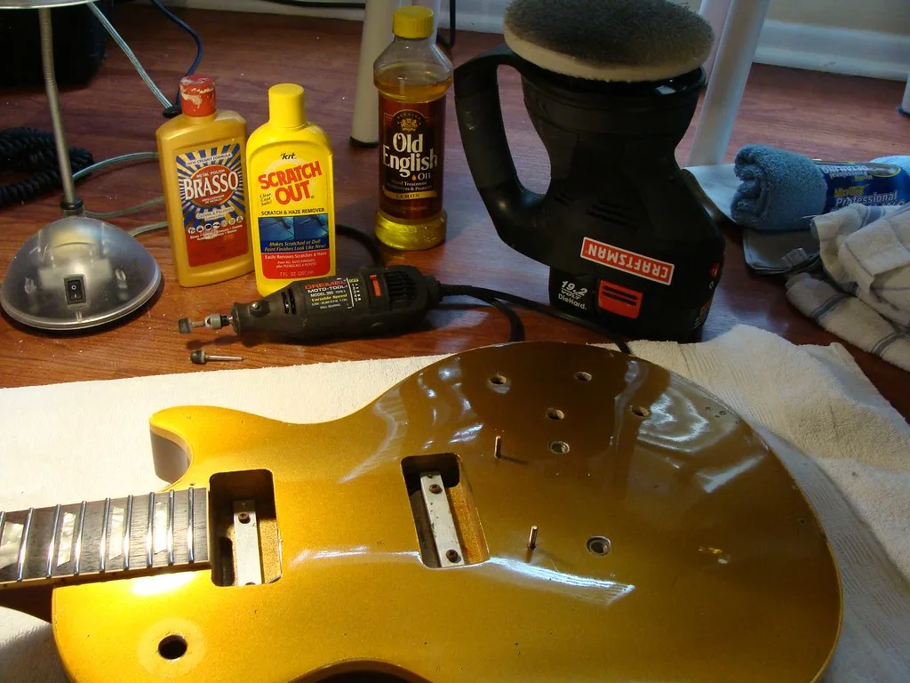 Hand applying Minwax Wood Finish Wax to a walnut table with a cloth in natural light