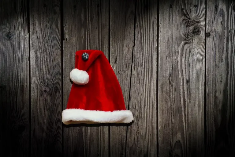 Three unfinished wooden Santa cutouts in different sizes beside tools on a workshop table