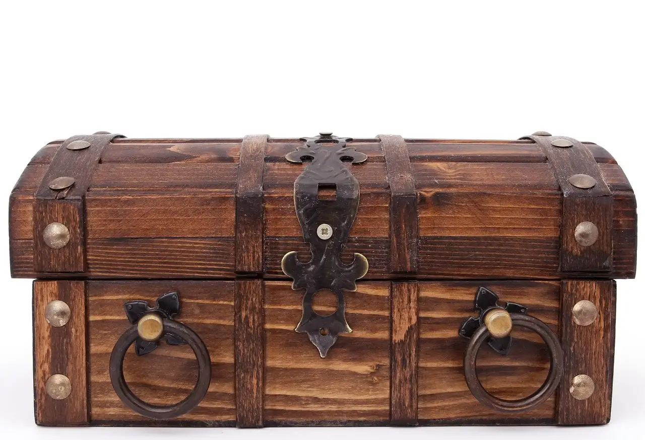 Partially built wood toy chest on a workbench with tools and pine boards
